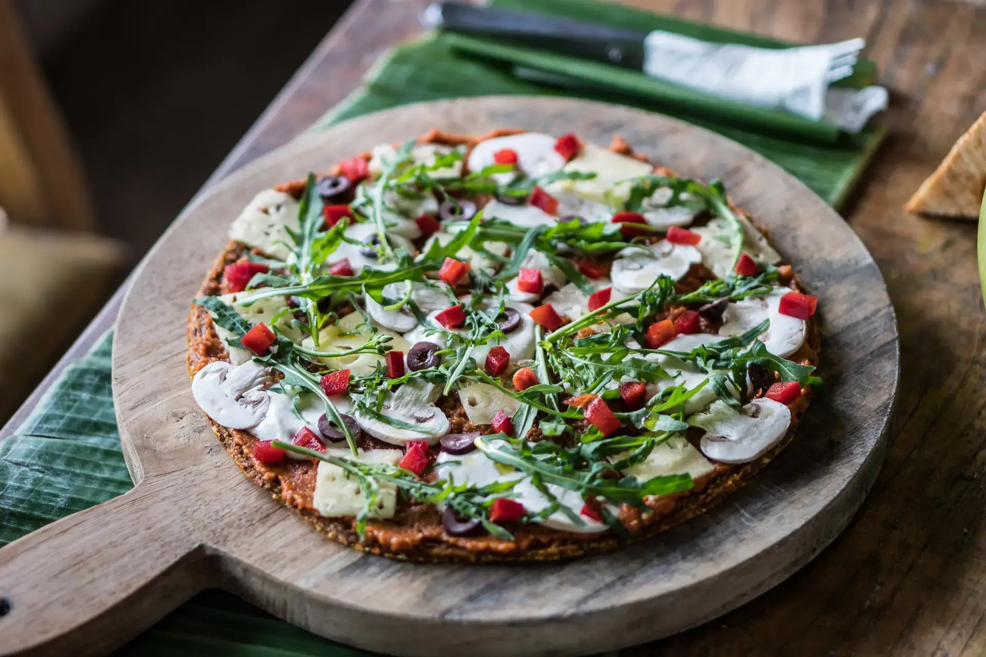 Vegan Pizza from Alchemy Bali, on wood table recipe in Bali Vegan Book