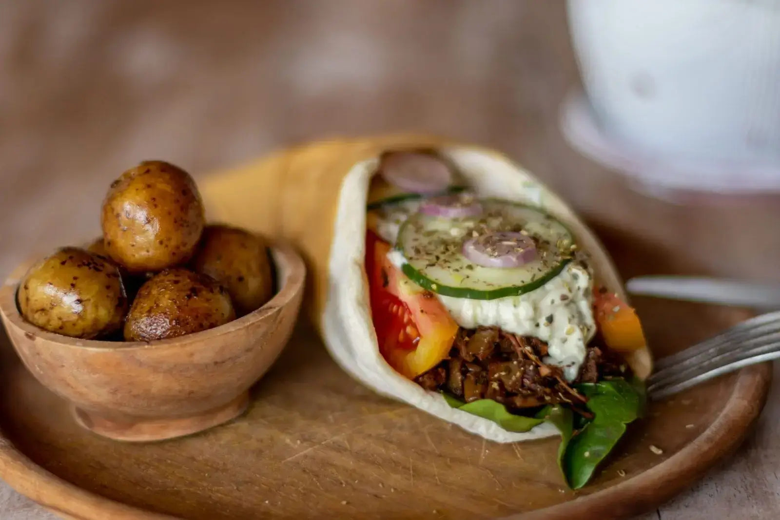 Vegan Gyro on wood plate with baby potatoes. Recipe from Bali Vegan Book